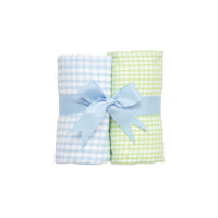 Two rolled checkered burp cloths - green and white check and blue  and white check - with a blue bow on a white background.