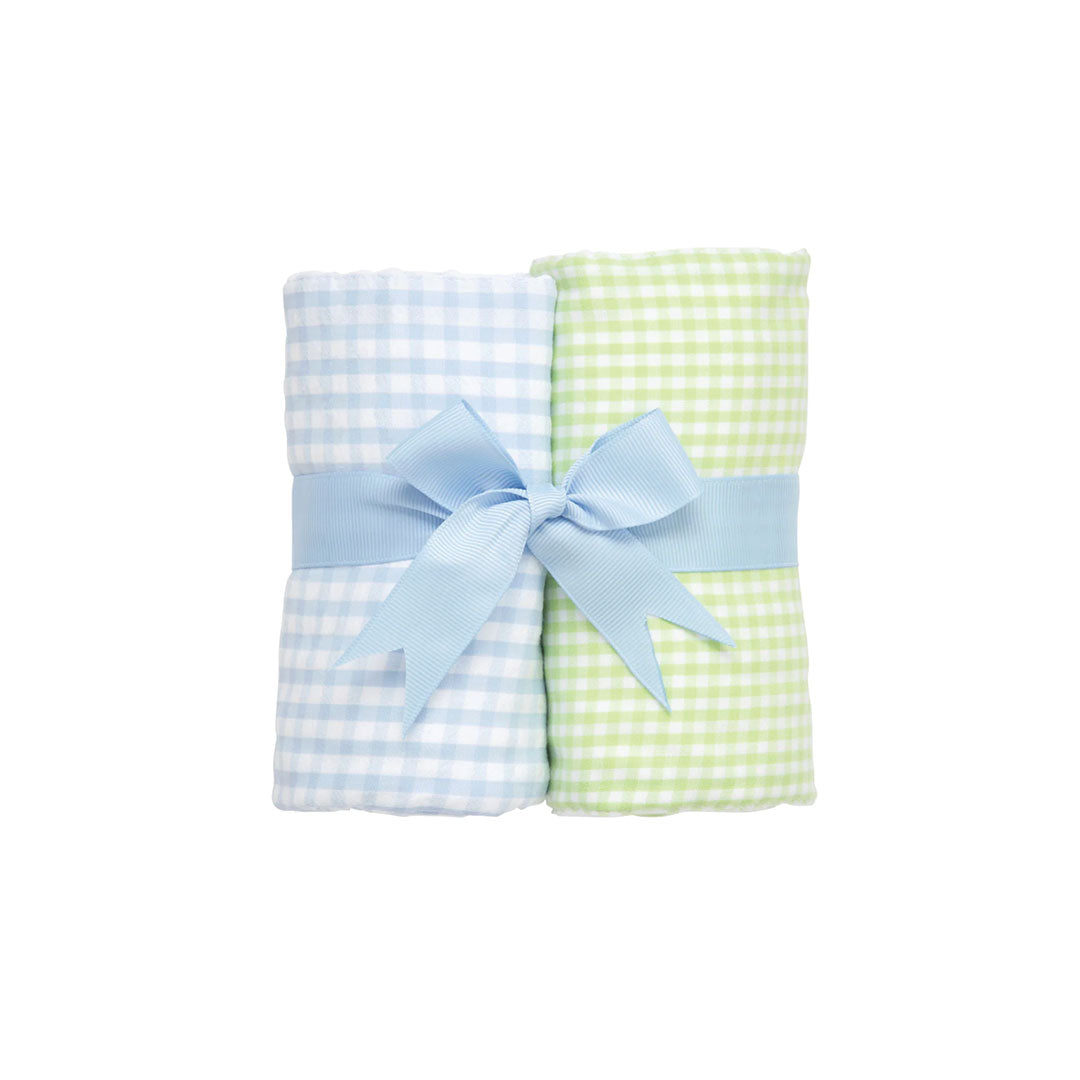 Two rolled checkered burp cloths - green and white check and blue  and white check - with a blue bow on a white background.