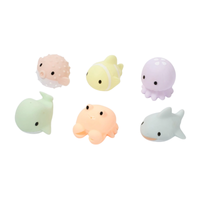 Set of six small sea animal toy figurines in pastel colors on a white background