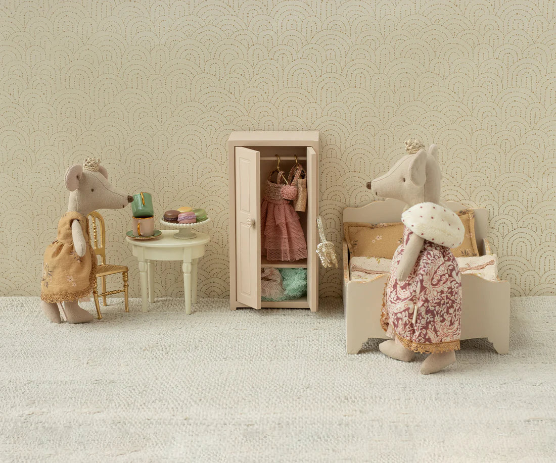 Miniature scene with toy mice in a room setting, including a wardrobe and furniture.