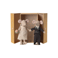 Two toy mice, one in a wedding dress and one in a tuxedo, standing in front of an open box with a decorative cover.