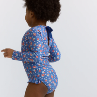 Model wearing a blue floral one piece long sleeve swimsuit 