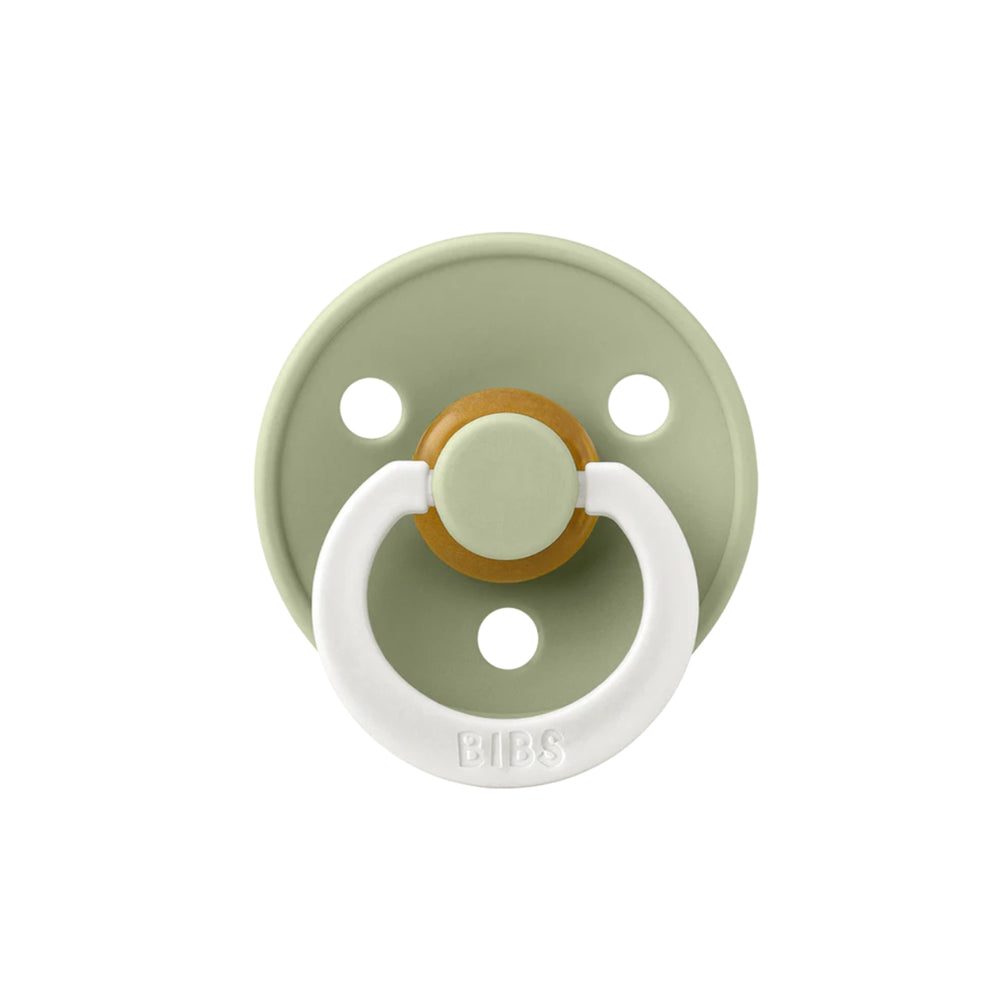 Sage green and white pacifier with a gold center on a white background.