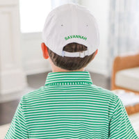 Person wearing a white cap with 'SAVANNAH' on the back, sitting in a room.