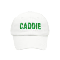 Child's white cap with 'CADDIE' in green text on a white background.