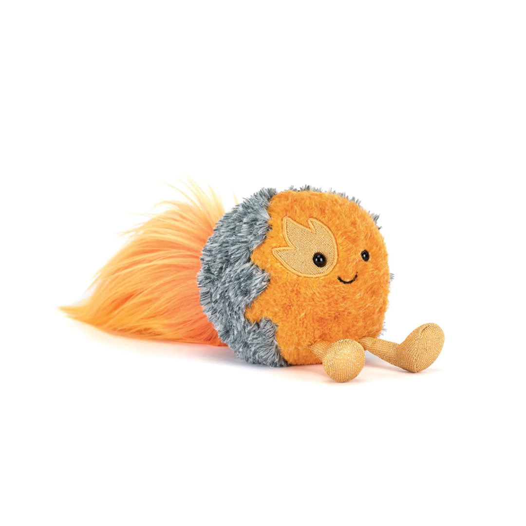 Plush toy representing a flying comet with orange body, long orange streaks of hair and gray spines on a white background.