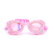 Pink heart-shaped swim goggles with glittery finish on a white background.