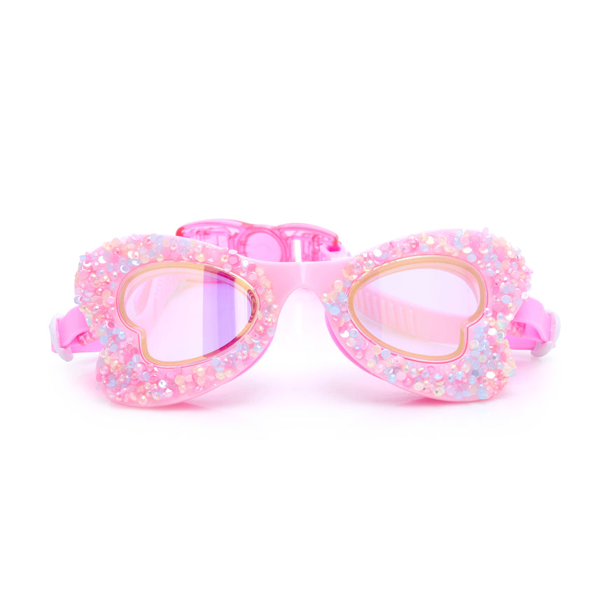 Pink heart-shaped swim goggles with glittery finish on a white background.
