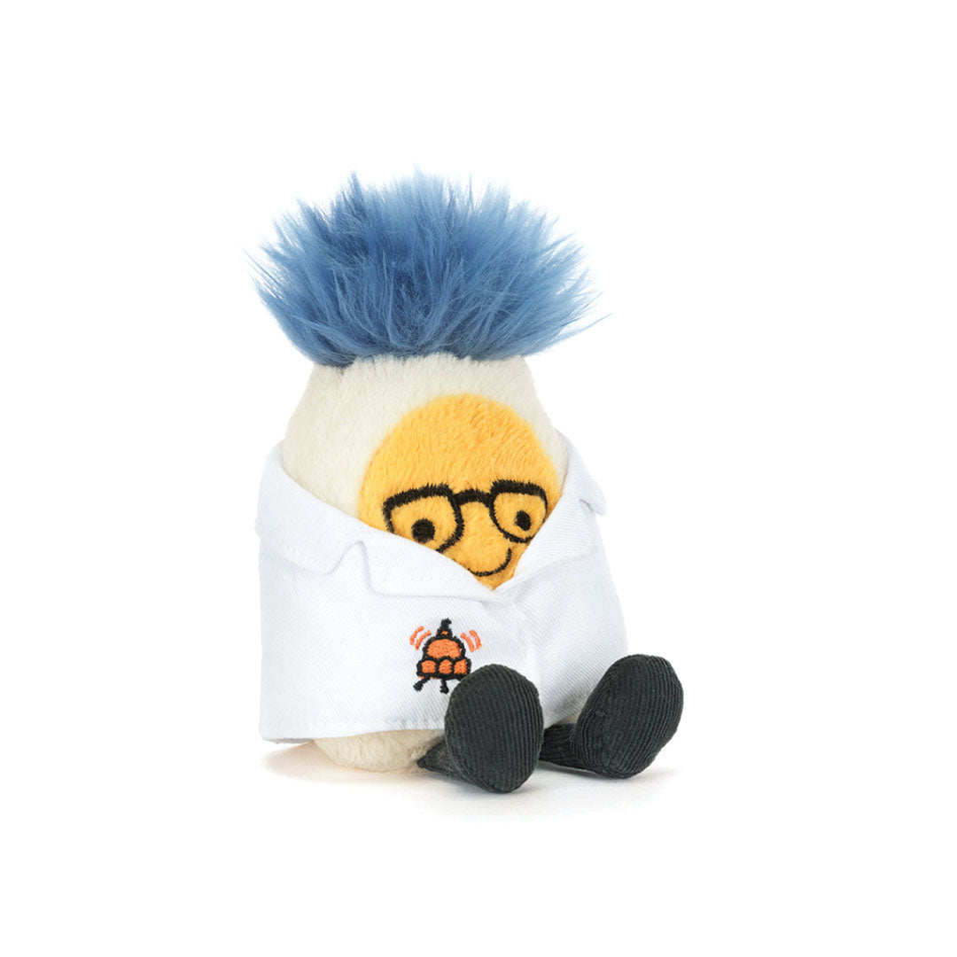 Toy stuffed egg with blue hair, yellow face, and white lab coat on a white background.