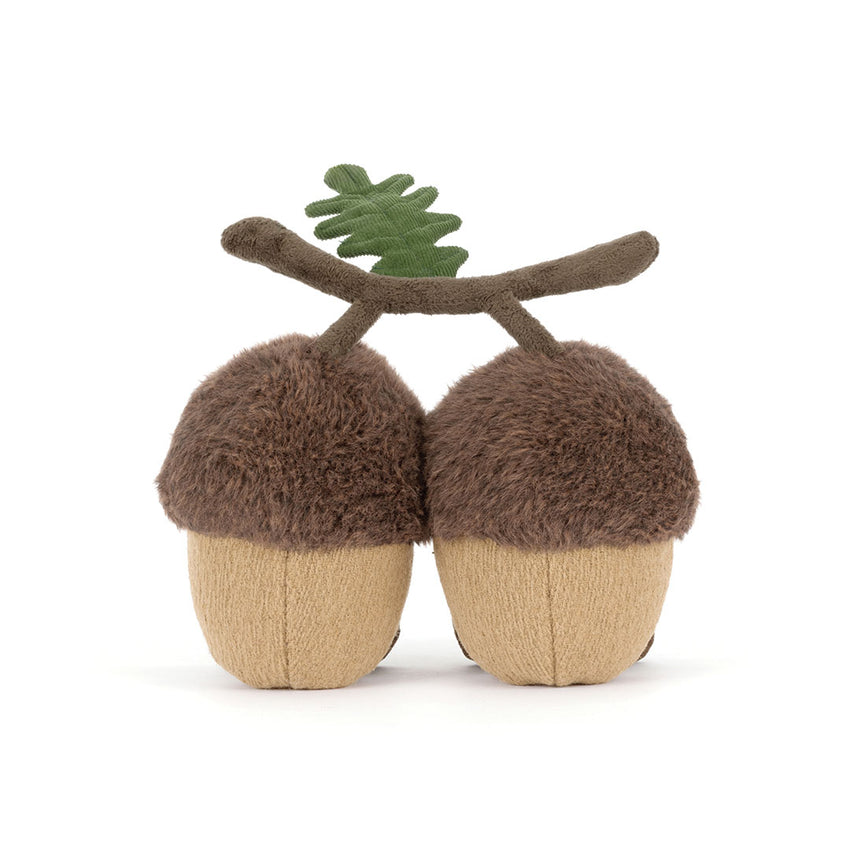 Back view of two stuffed acorn toys connected with a branch on a white background.