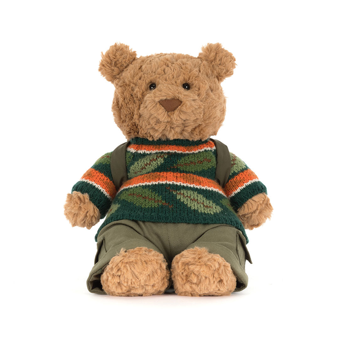 Front view of a teddy bear wearing a dark striped knit sweater, photographed on a white background.