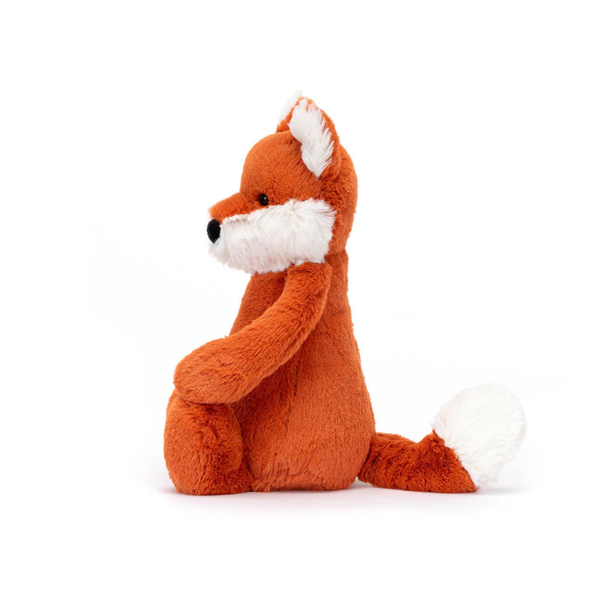 Side view of a plush fox toy sitting upright on a clean white background. The toy is made of soft orange-brown faux fur with white accents on its chest, inner ears, and tail tip, and has small black embroidered eyes and nose.