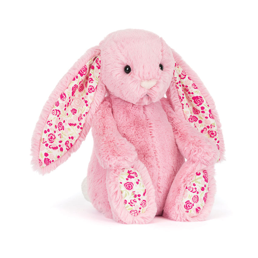 A pink plush bunny toy with long floppy ears and a pink floral pattern lining, sitting against a plain white background.