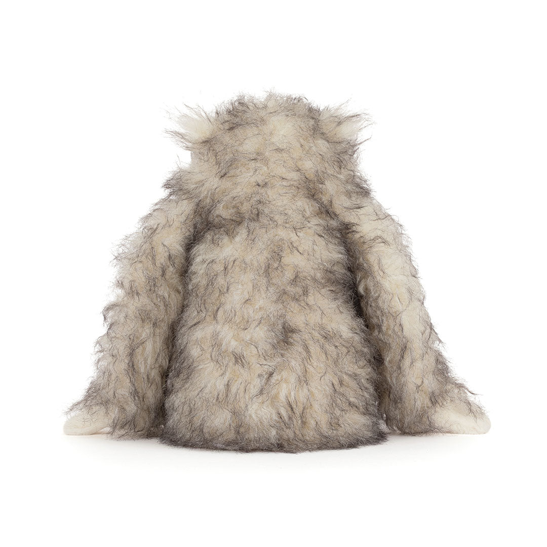 Back view of a fluffy gray and white furry "yeti" critter plush toy sitting against a plain white background.