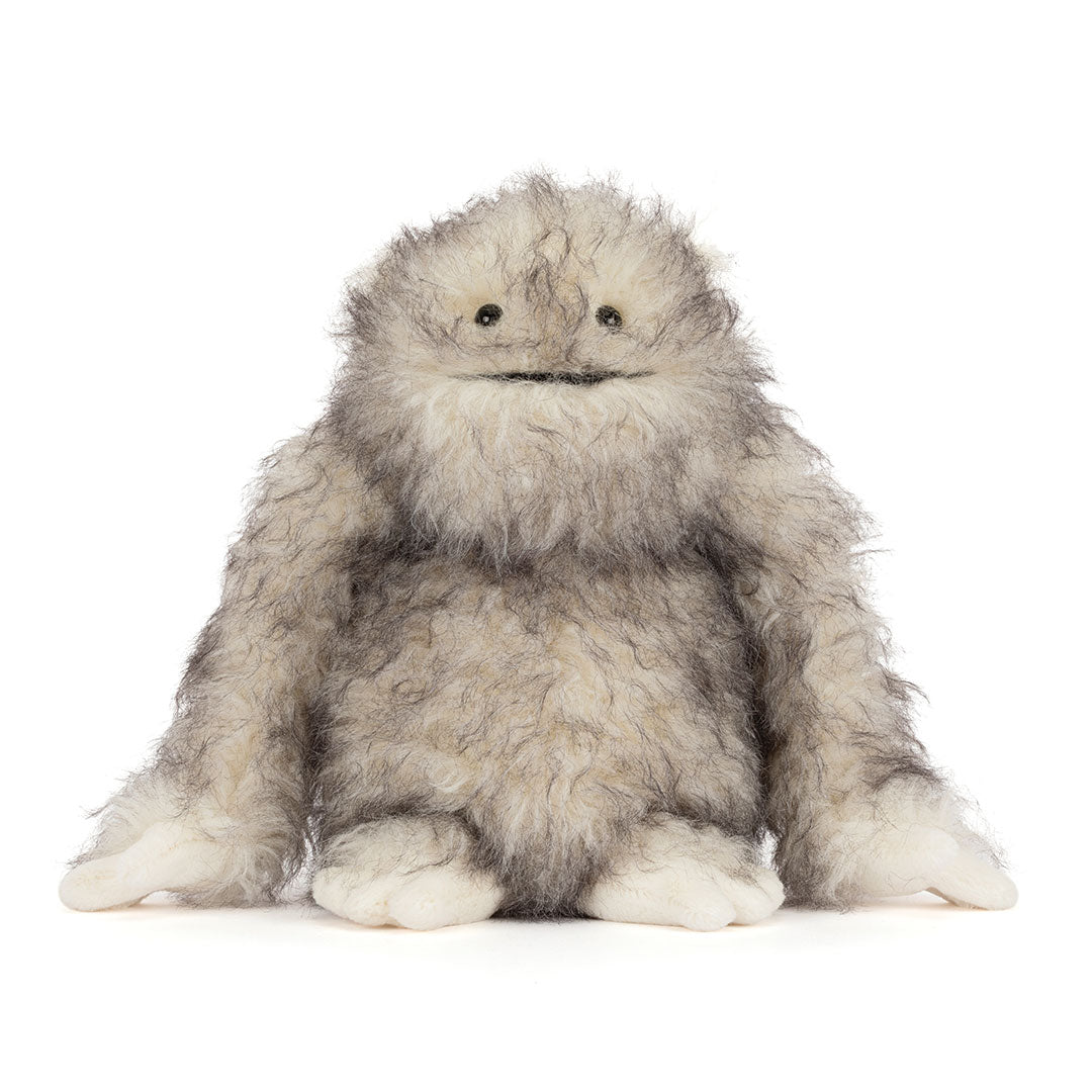 A fluffy gray and white furry "yeti" critter plush toy with small black eyes and a stitched smile, sitting against a plain white background.