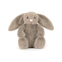A plush stuffed bunny toy in a warm taupe-gray color, sitting upright against a clean white background.