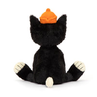 The back of a black and white plush cat stuffed animal wearing an orange hat on a white background.