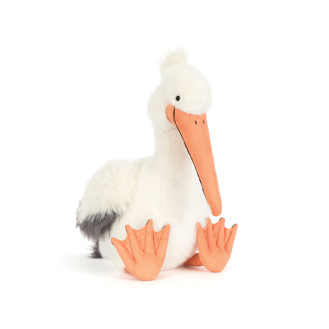 A plush toy pelican with a white fluffy body, a long orange beak, and orange webbed feet, photographed on a clean white background.