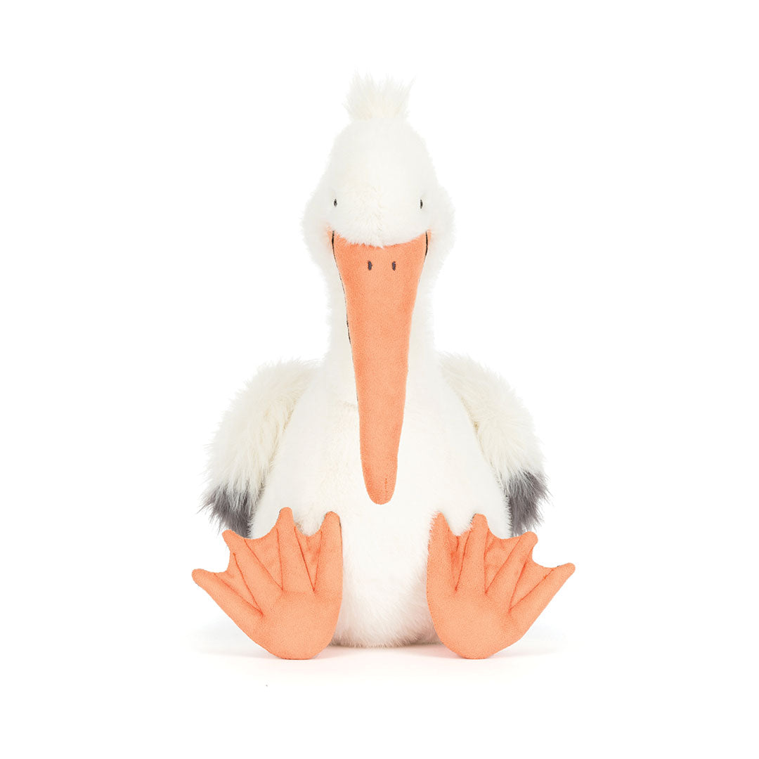 Stuffed toy pelican with a white body, black wings, and orange beak and feet on a white background