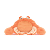 A plush orange crab toy with large white claws and small orange eyes, photographed against a plain white background.