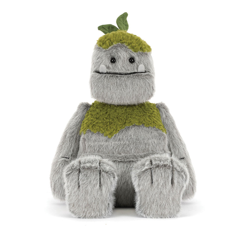 A plush toy character with a fuzzy gray body, olive green textured chest and headpiece with small green leaves, sitting against a plain white background.