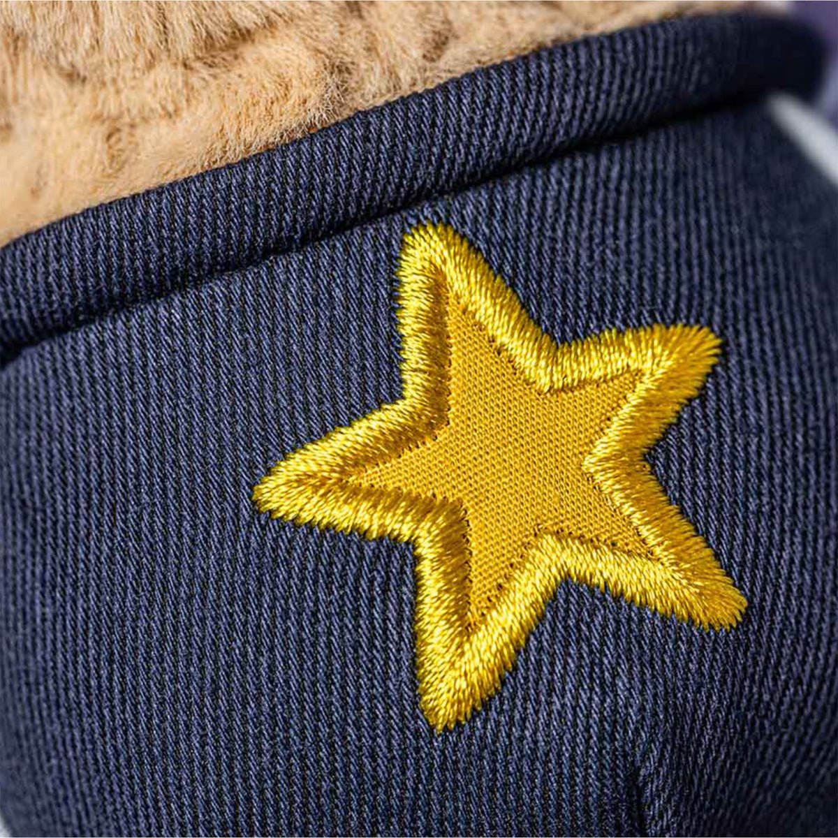 Details of star on plush toy peanut in star student outfit - navy outfit with gold star 
