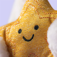 Close up of gold cookie being held by a white bunny on a white background.