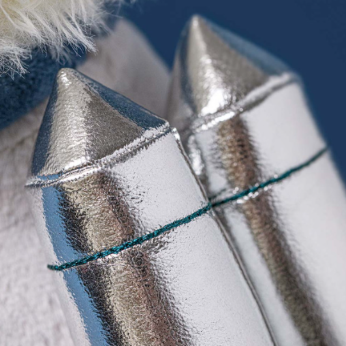 Close-up of metallic rockets on a stuffed animal with a blue background.
