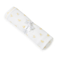 Rolled-up white baby blanket with yellow duck pattern on a white background.
