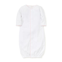 White gathered at bottom converter gown with pink trim on a white background.