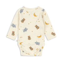 Back view of a long-sleeve baby bodysuit in cream with an all-over print of teddy bears, elephants, crescent moons, and stars in brown, blue, and yellow.
