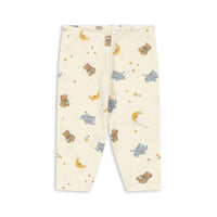 A pair of baby leggings with an off-white background featuring a playful print of teddy bears, blue elephants, yellow crescent moons, and small stars.