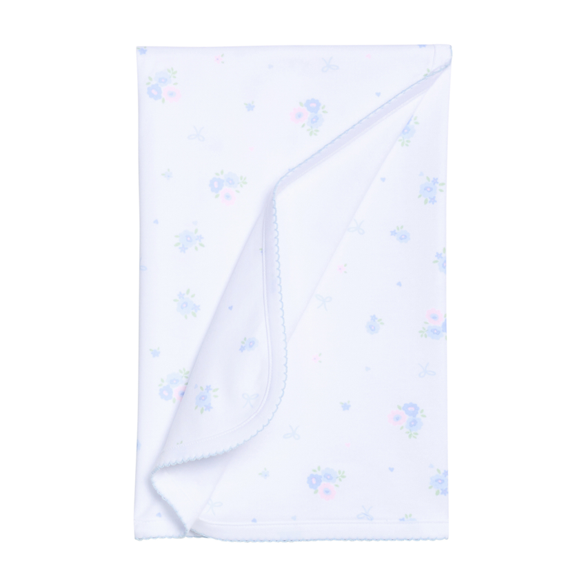 White baby blanket with blue floral patterns on a white background.