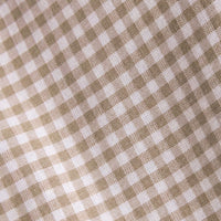 A close-up of a woven fabric with a small gingham check pattern in warm beige and white.