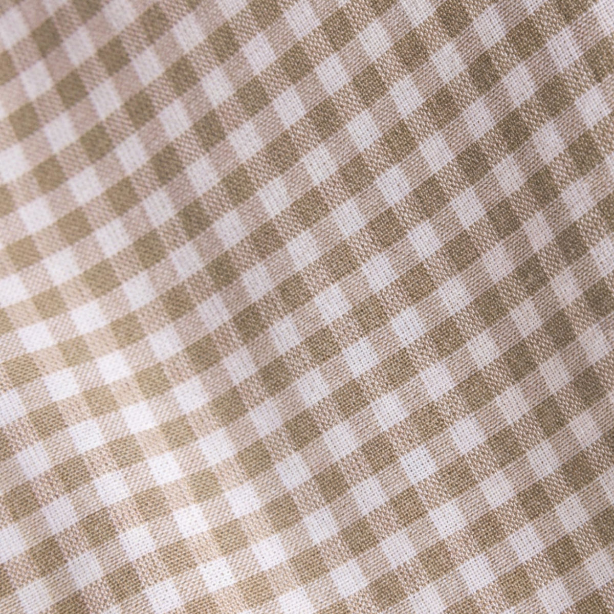 A close-up of a woven fabric with a small gingham check pattern in warm beige and white.