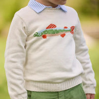 A cream colored sweater with an intarsia trout on the chest.  Model wearing green pants in an outdoor setting.