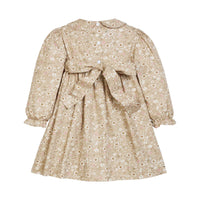 Back view of a  toddler girl's long-sleeve dress with a beige and white floral print, featuring a Peter Pan collar, puffed sleeves, and a matching fabric bow tied at the back waist.
