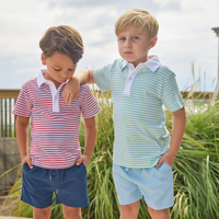 Two boys outside wearing striped t-shirts and shorts.