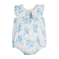 Back view of a baby romper with blue floral pattern and a bow on a white background.