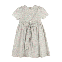 A short-sleeve dress with a small-scale floral print in muted green, pink, and beige tones on a white base. It features a buttoned back, a gathered waist, and a matching fabric tie belt, shown against a plain white background.