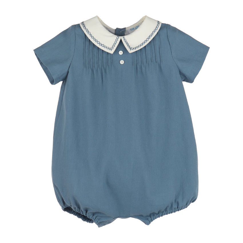 Teal blue boy bubble with chest pleats, a white collar with embroidery and short sleeves on a white background.