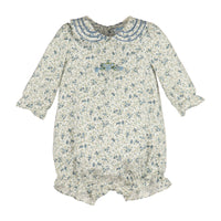 A baby long-sleeve romper in a cream-colored fabric with a blue and green floral print, featuring a ruffled Peter Pan collar and a small embroidery on the chest.