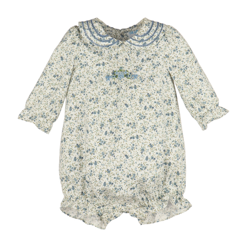 A baby long-sleeve romper in a cream-colored fabric with a blue and green floral print, featuring a ruffled Peter Pan collar and a small embroidery on the chest.