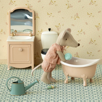 Miniature bathroom set with a toy mouse in a bathtub, sink, and toilet.