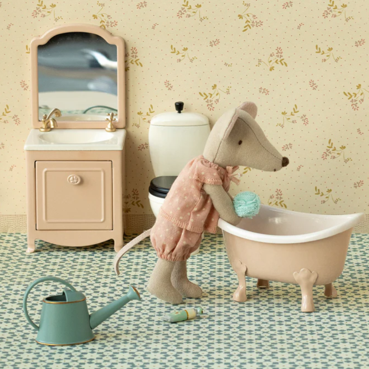 Miniature bathroom set with a toy mouse in a bathtub, sink, and toilet.