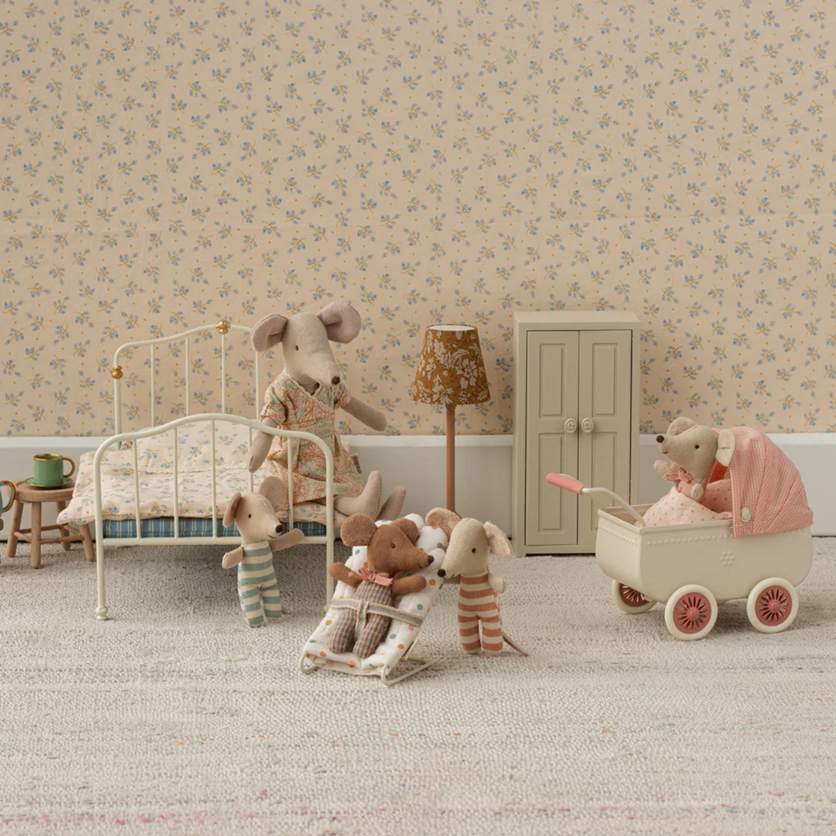 Miniature mice in their bedroom with floral wallpaper and a bed.  Bed, pram and other furniture.