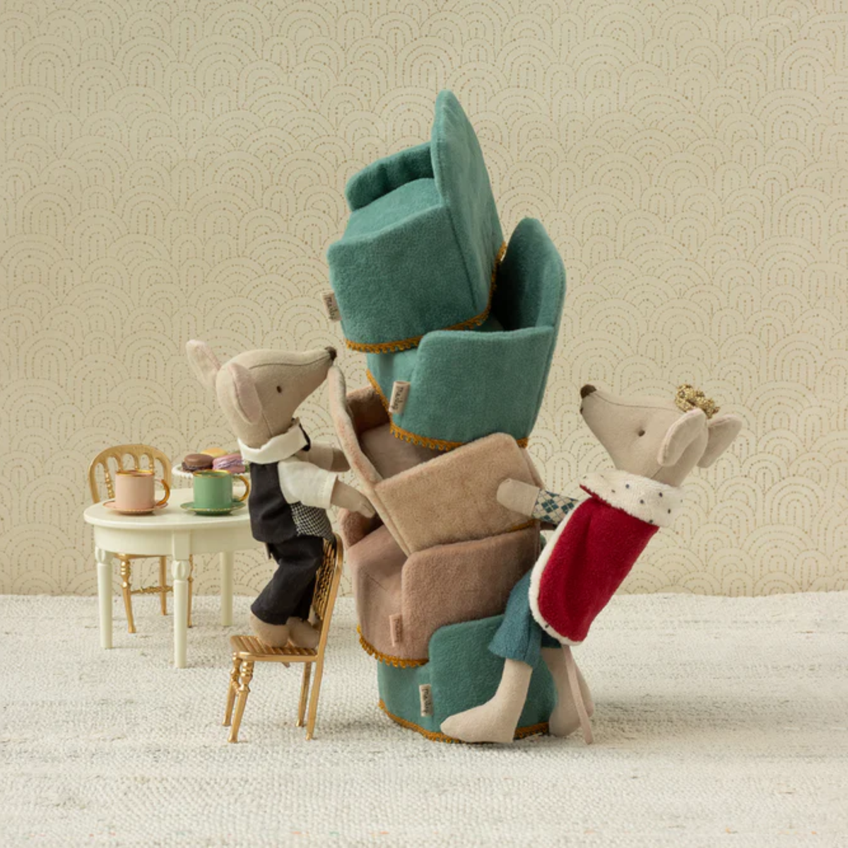 Stack of plush toy chairs with a small King mouse and butler mouse  around a miniature table and chairs.