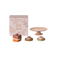 Miniature cake, pastries, and decorative stand with 'Petit fours' box on a white background.