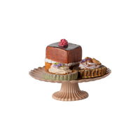 Decorative cake stand with small cakes on a white background.