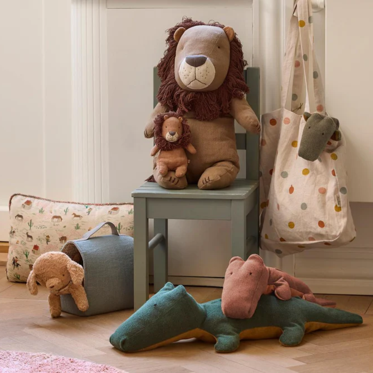 Children's room with plush toys including a lion, bear, and crocodile on a chair and floor.